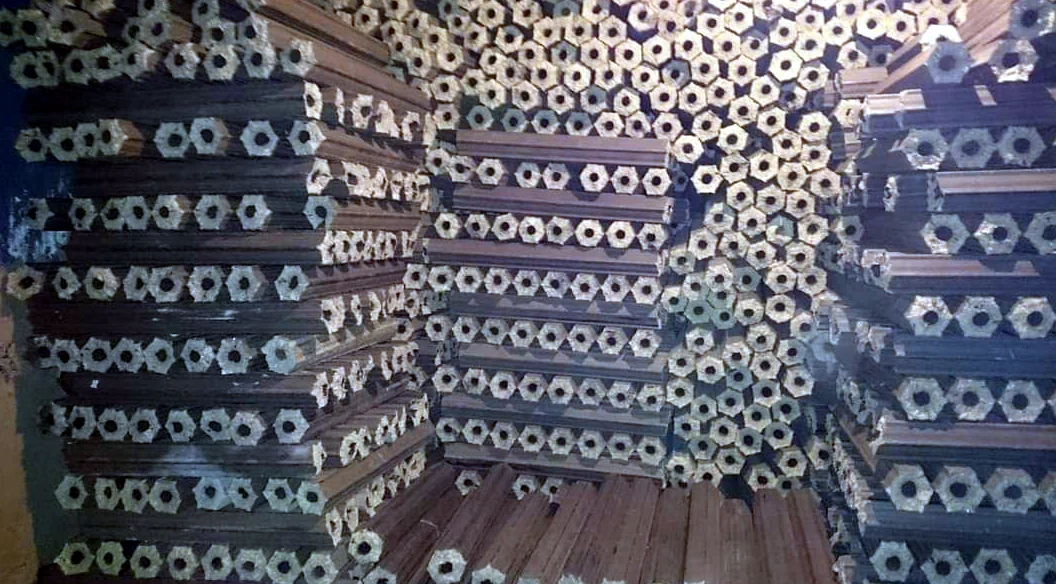 Pilas de troncos de leña de serrín secados en horno VUTRUX en el almacén de la fábrica