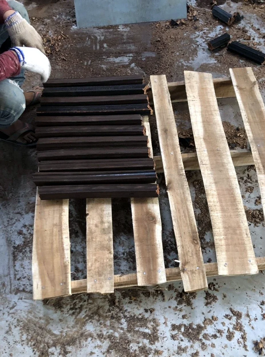 Troncos de leña de serrín VUTRUX recién fabricados dispuestos sobre un palé de madera